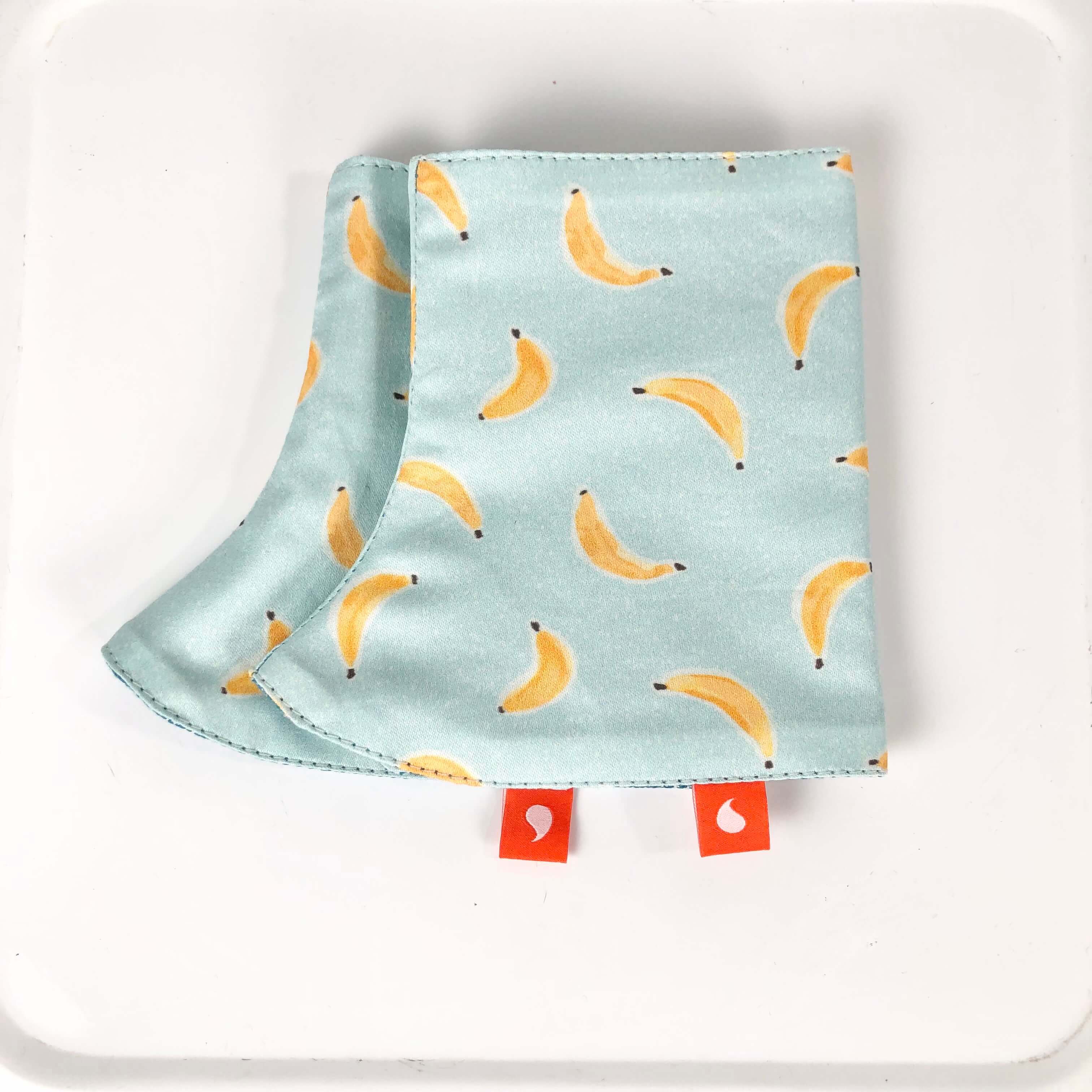 Protège de bretelles pour porte-bébé. Coton biologique, tissu d'écharpe bleu chiné, imprimé petites banane sur fond bleu ciel. Fabriqué en France.